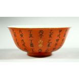 A CHINESE CORAL GROUND PORCELAIN BOWL, the exterior decorated with calligraphy, four character