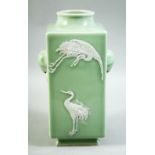 A CHINESE CELADON GLAZE SQUARE FORM VASE, decorated with carved cranes and two moulded ring handles,