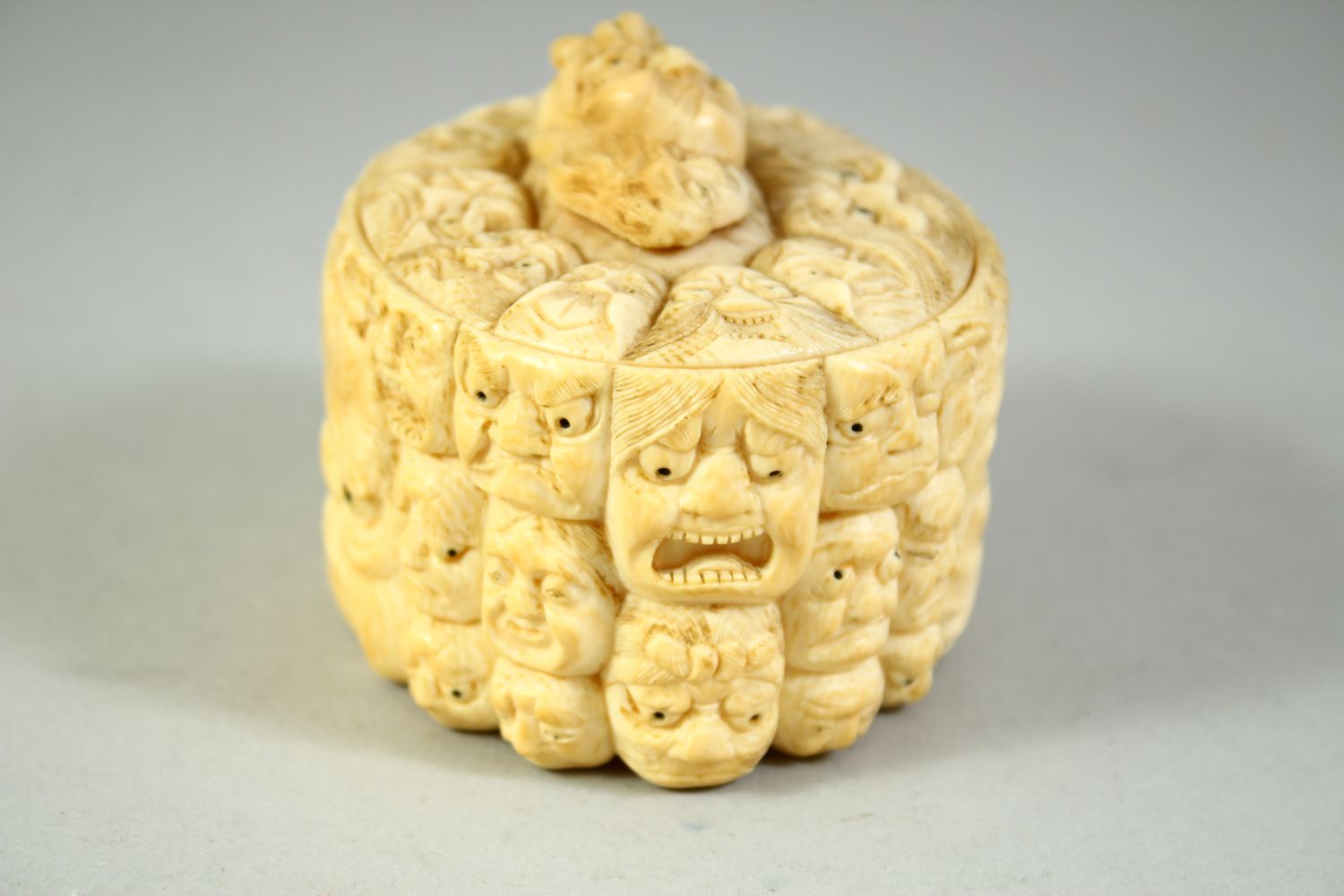 A JAPANESE CARVED IVORY NOH MASK BOX AND COVER, the box carved all over with various theatre masks - Image 4 of 8