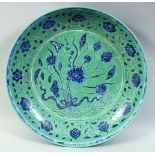 A LARGE CHINESE TURQUOISE GROUND PORCELAIN DISH, the centre painted with a floral spray surrounded