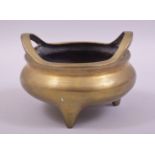 A GOOD CHINESE BRASS TWIN HANDLE TRIPOD CENSER, the base with mark, 14cm diameter.