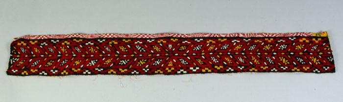 A TURKAMAN BELT, black ground, embroidered in red and yellow thread to geometric design, 75cm x