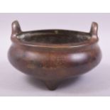 A CHINESE BRONZE TWIN HANDLE TRIPOD CENSER, with four character mark to base, 15cm diameter.