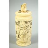 A SMALL JAPANESE CARVED IVORY CYLINDRICAL POT AND COVER, carved with various figures in an outdoor