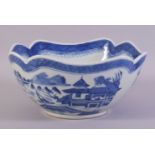 A CHINESE BLUE AND WHITE PORCELAIN BOWL, decorated with a landscape including buildings, boats and
