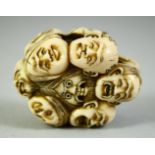 A JAPANESE CARVED IVORY NETSUKE, carved as a roundel of noh masks, 5.5cm.