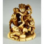 A JAPANESE CARVED IVORY NETSUKE, depicting a playful scene with a male and female figure with