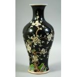 A CHINESE FAMILLE NOIR PORCELAIN VASE, decorated with prunus blossom and birds, 28cm high.