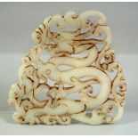 A CHINESE CARVED AND PIERCED AMULET DEPICTING A DRAGON, 8cm x 8cm.