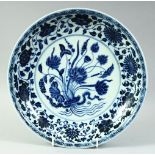 A CHINESE BLUE AND WHITE PORCELAIN PLATE, the centre with floral spray and lotus, further