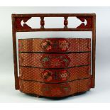 A CHINESE RED LACQUER FOUR TIER STACKING BOX with handle, the cases decorated with auspicious