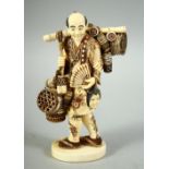A JAPANESE CARVED IVORY OKIMONO, depicting a basket seller, with inset mother of pearl seal to base,