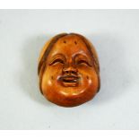 A SMALL CARVED WOOD NETSUKE, okame mask, 2.5cm.