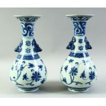A PAIR OF CHINESE BLUE AND WHITE PORCELAIN VASES, with formed handles and floral decoration, 27.
