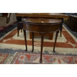 A George III small mahogany demi-lune foldover tea table (alterations).