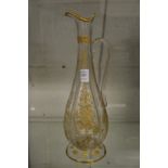 A gilt decorated engraved glass claret jug.