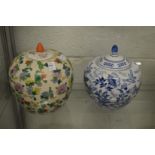 A large Chinese Famille Rose style jar and cover and a similar blue and white jar and cover.