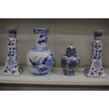 A Chinese blue and white vase and similar pair of candlesticks and a jar and cover.