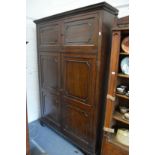 A large mahogany standing four-door cupboard.