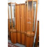 A unique walnut display cabinet on stand with four central doors flanked by octagonal shaped display