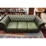 A green leather upholstered three-seater Chesterfield settee.