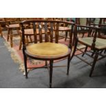 An Edwardian inlaid mahogany horseshoe shaped armchair.