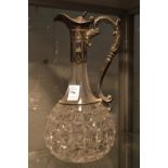 A cut glass claret jug with plated mount.