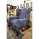 A large blue upholstered wing armchair.