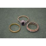 A gold, diamond and sapphire ring, a gold wedding band and an eternity ring.