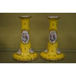 A pair of yellow porcelain candlesticks.