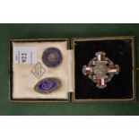 A nurse's silver and enamel brooch in original box, together with two others.