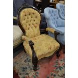 A Victorian button upholstered mahogany framed open armchair.
