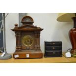 A mantle clock and a miniature chest of drawer.