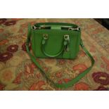A Michael Kors green leather handbag.