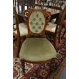 A Victorian carved walnut and upholstered occasional chair.