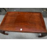 A Chinese rosewood low table with curving ends.