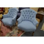 A pair of pale blue upholstered button back armchairs.