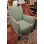 An Edwardian small upholstered armchair made by Shoolbred.