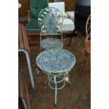 A decorative metal folding patio chair and matching circular table.