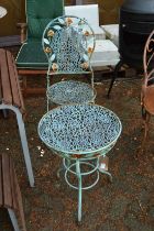 A decorative metal folding patio chair and matching circular table.