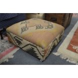 A large Kilim upholstered footstool.