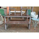 A stylish slatted hardwood and metal framed patio with bench sets and pair of matching stools/
