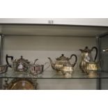A silver plated three-piece tea service and a plated four-piece tea service with engraved
