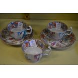 A pair of Chinese Canton cups and saucers and another single cup.