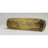 A LONG DUTCH BRASS TOBACCO BOX AND COVER, decorated with circular vignettes. 16cm long, 4.5cm wide.