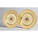 A GOOD PAIR OF AYNSLEY FRUIT PLATES with gold borders. 10ins diameter.