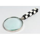 A MAGNIFYING GLASS with chequered handle.