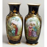 A GOOD PAIR OF SEVRES DARK BLUE PORCELAIN VASES edged in gilt and painted with young ladies. 15