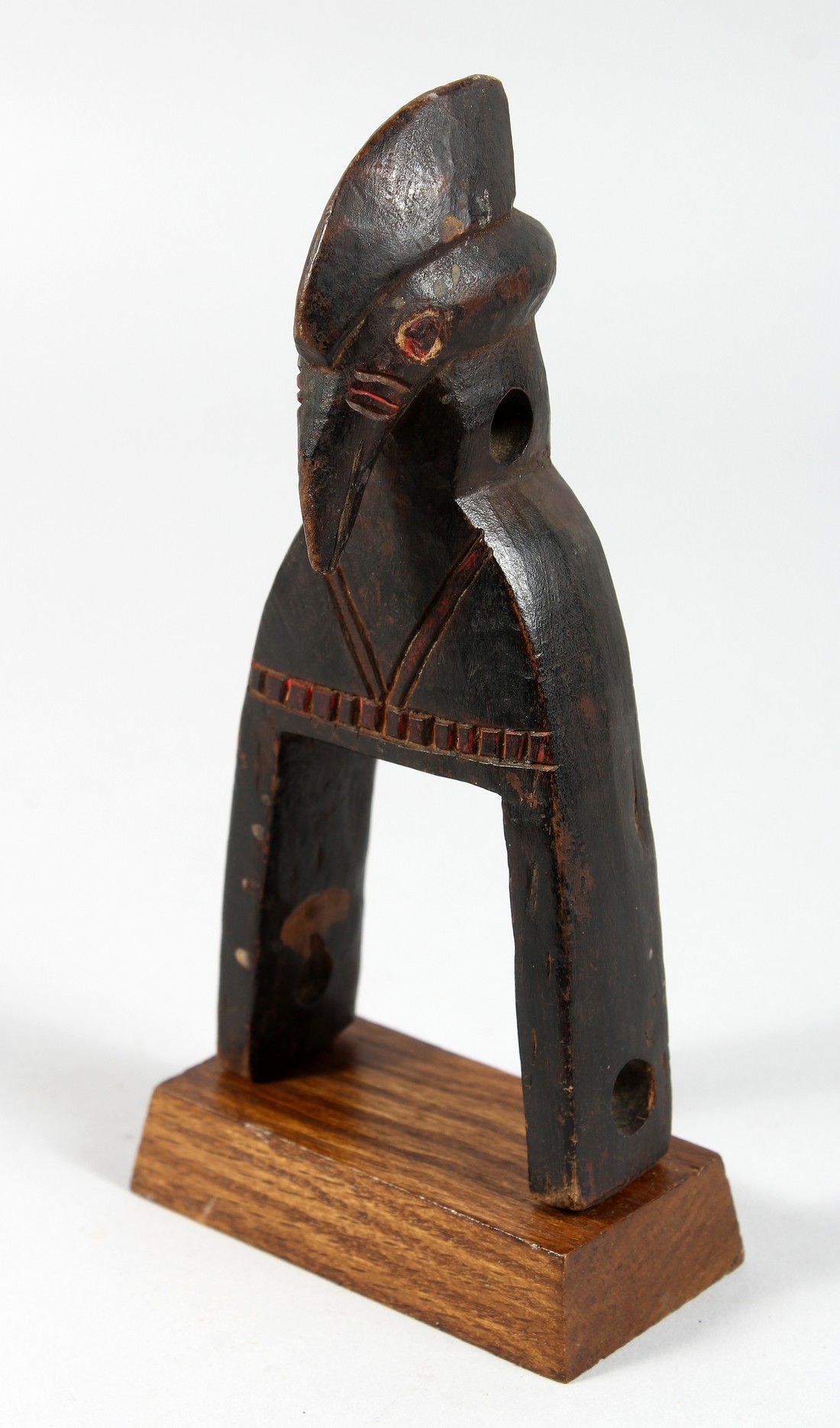 A CARVED WOOD TRIBAL BIRD'S HEAD PULLEY. 7.5ins high.