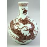 A CHINESE COPPER RED AND WHITE PORCELAIN DRAGON VASE, the body painted with a large dragon amongst